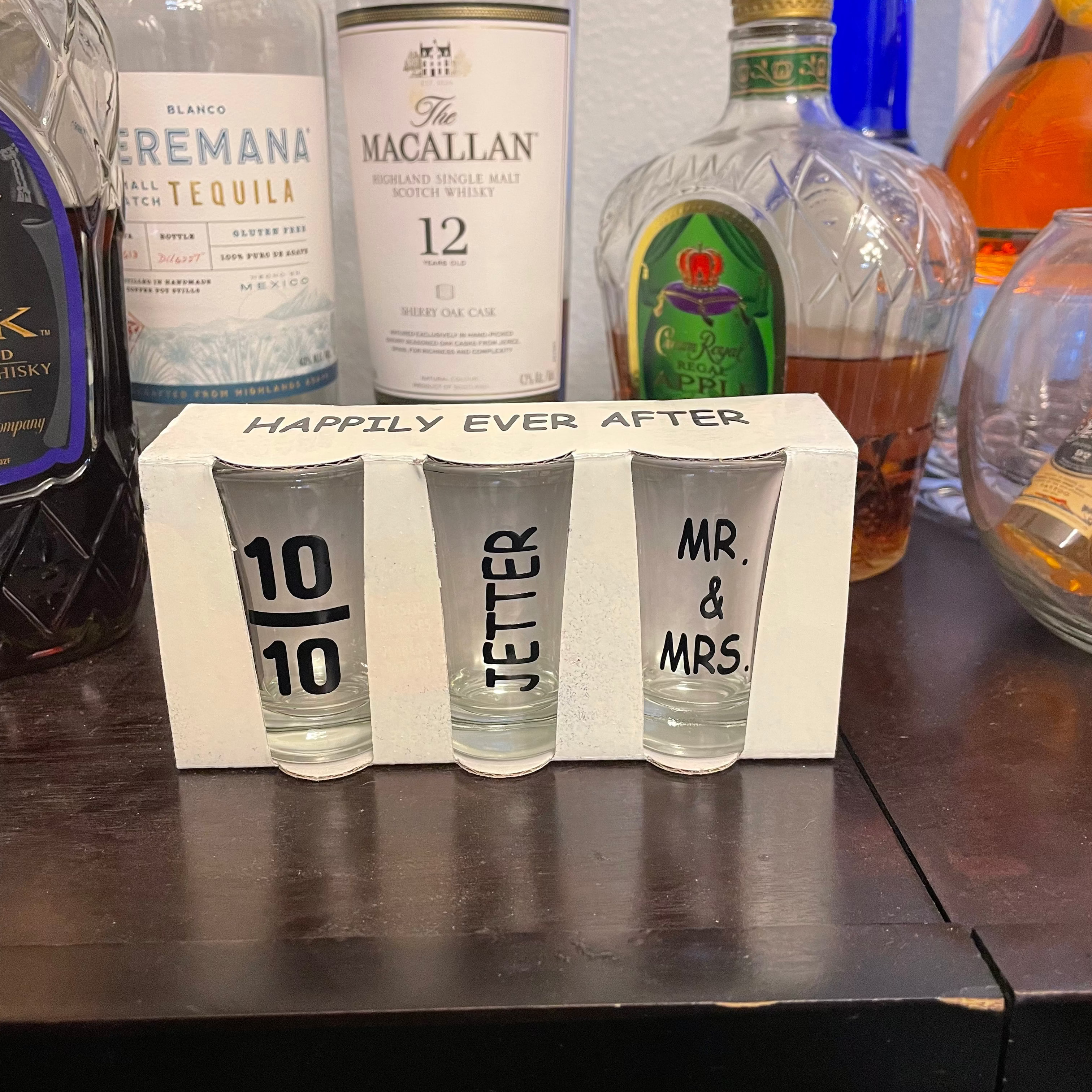 Engraved wedding shot glasses displayed as reception bar décor