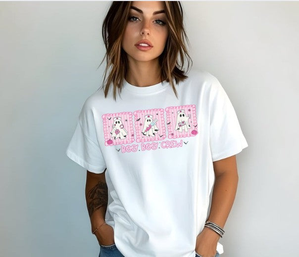 Person wearing a white t-shirt with pink graphics and text on a plain background